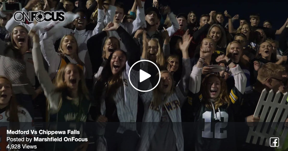 Crowd of enthusiastic fans cheering at a high school football game, showcasing community spirit and engagement in rural America.