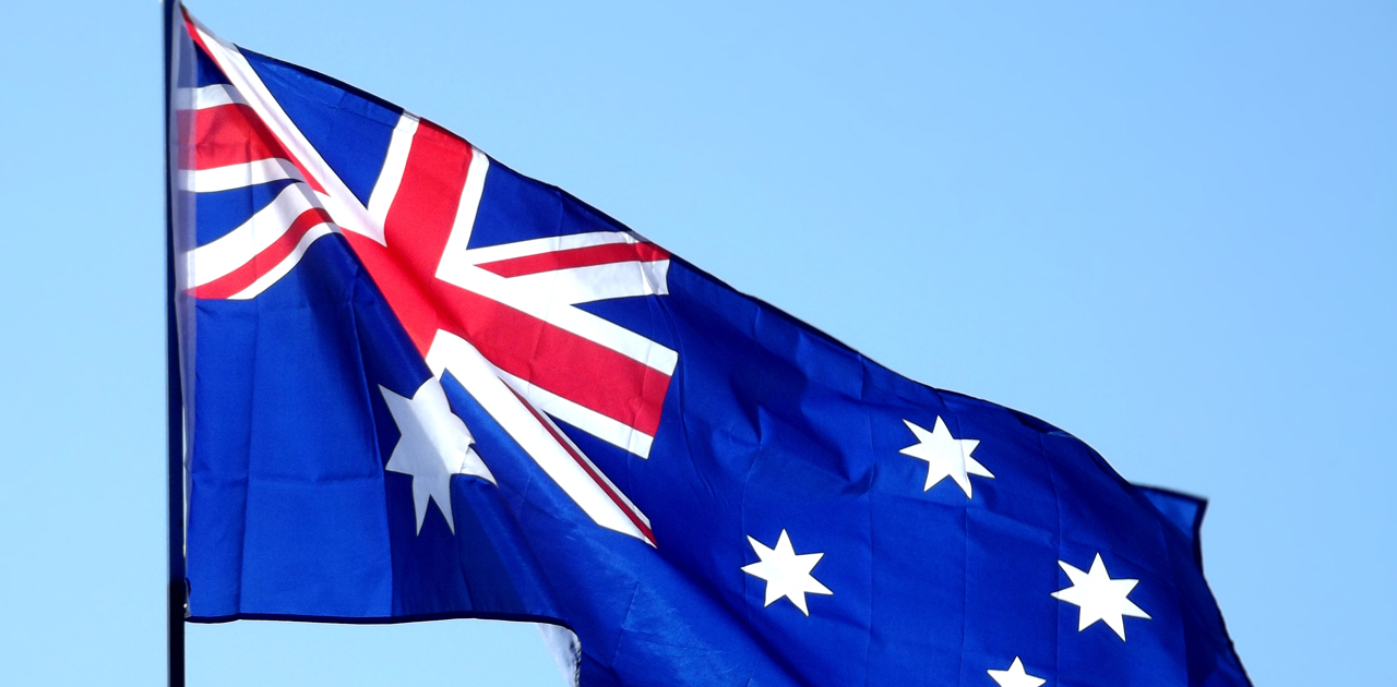Australian flag waving in blue sky, symbolizing business empowerment and financial planning for Australian business owners.